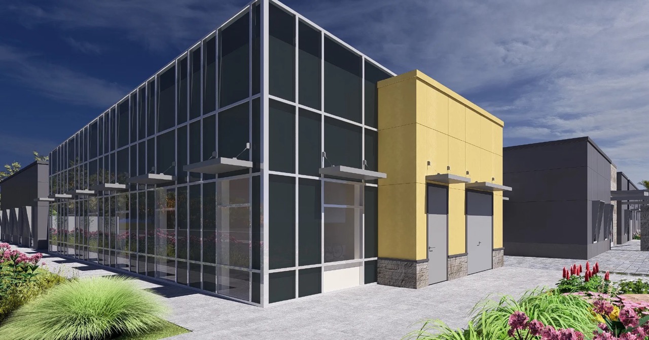 Modern glass building with yellow accent, surrounded by landscaping and a paved walkway under a blue sky—an ideal space for investing or lending opportunities.