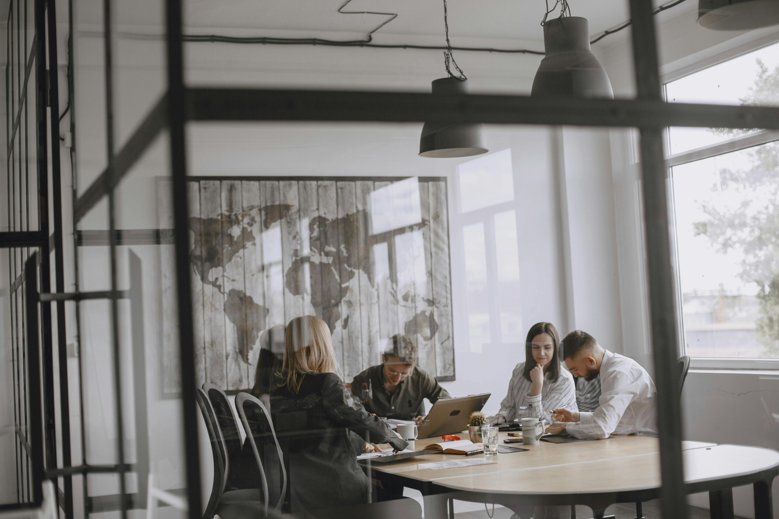 Four people sit around a conference table in a modern office, engaged in a meeting or discussion about findings from a national study on supportive housing.